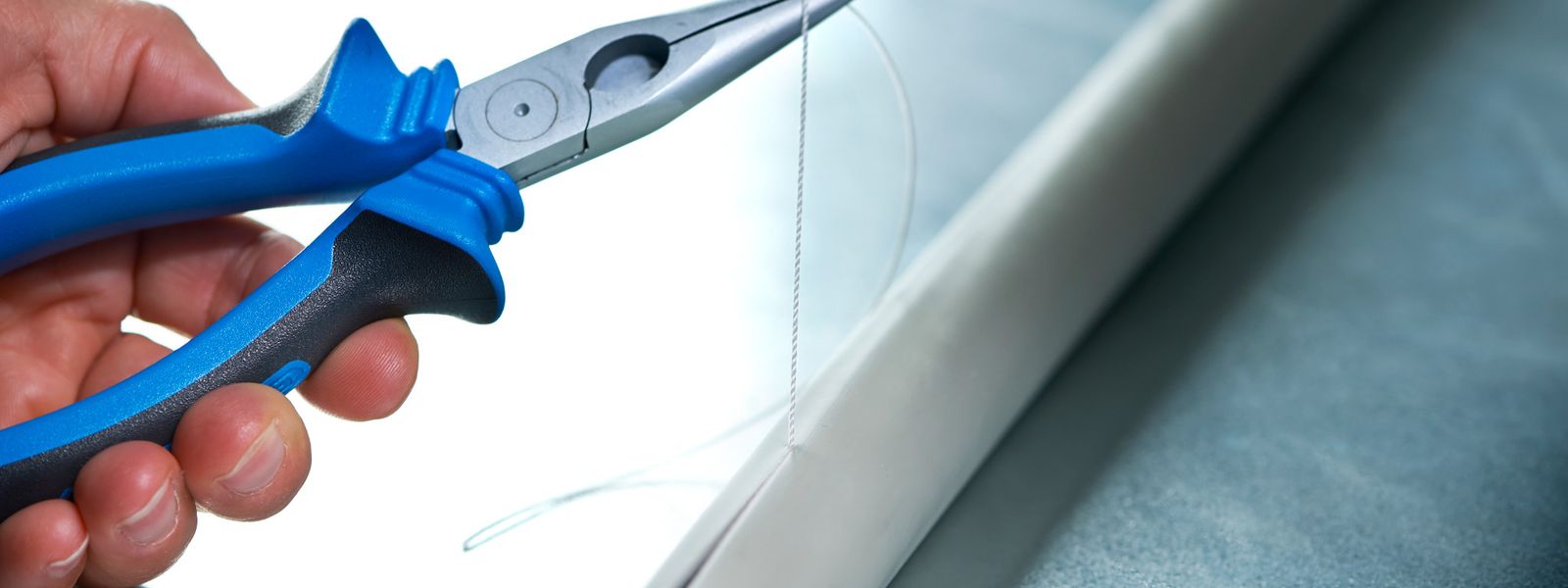 Installer using rip cord to open sheath on low voltage cable