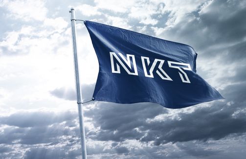 NKT flaf flying in the wind with grey sky